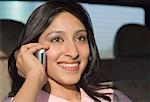 Nahaufnahme einer jungen Frau, die auf einem Mobiltelefon im Auto sprechen