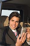 Close-up of a businessman using a personal data assistant in a car