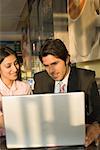 Businessman and a businesswoman using a laptop