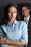 Portrait of a businesswoman standing with a businessman behind her