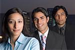 Portrait of a businesswoman standing with two businessmen behind her