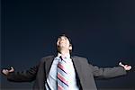 Low angle view of a businessman smiling with his arms outstretched