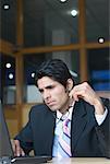 Businessman using a laptop in an office and thinking