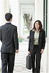 Portrait d'une femme d'affaires et un homme d'affaires marchant dans le couloir