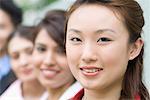 Portrait of a businesswoman smiling with her colleagues behind her