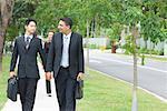 Two businessmen looking at each other and walking