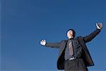 Low angle view of a businessman with his arms outstretched