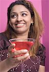 Close-up of a young woman holding a martini and smiling