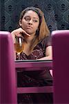 Young woman sitting in a restaurant and thinking