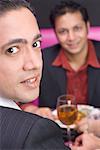 Portrait of a mid adult man sitting with a young man in a restaurant