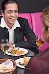 Mid homme adulte et une jeune femme assise à une table dans un restaurant