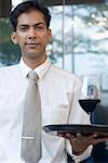 Porträt eines Mitte Erwachsenen Mannes mit einem Glas Rotwein auf einem Tablett