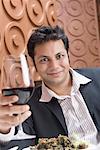Portrait d'un jeune homme tenant un verre de vin rouge