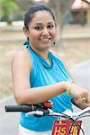 Portrait of a mid adult woman standing with a bicycle and smiling