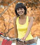 Portrait of a mid adult woman standing with a bicycle and smiling