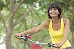 Close-up of a mid adult woman holding a bicycle and smiling