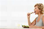 Senior woman eating vegetable kebab