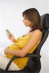 Pregnant Businesswoman Reading Text Message