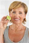 Senior woman holding a slice of lime