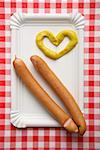 Two wieners with heart-shaped mustard