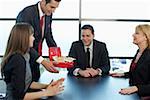 Businesspeople looking at a cash box with banknotes