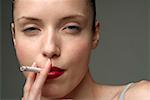 Young woman smoking a cigarette (part of), close-up