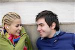 Smiling young couple fact to face woman with earphones