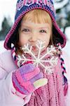 Girl holding a snowflake  at camera