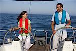 Two people steering a boat