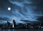 Night skyline of futuristic city with full moon