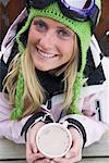 Young woman in ski-wear with cup of hot chocolate, close-up, high angle, portrait