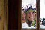 Two young blonde women in ski-wear looking into window