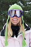 Close-up portrait of young blonde woman wearing ski-wear in forest