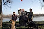 Grandparents, grandson (12-14) and granddaughter (10-12) with two dogs by river