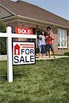 Portrait of Family by House with Sold Sign