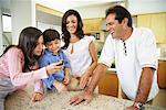 Family in kitchen, Looking at Cell Phone