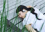 Woman lying on decking listening to headphones