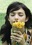 Woman smelling flowers, eyes closed