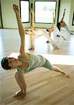 Yoga-Klasse tut der Dreieck-Stellung