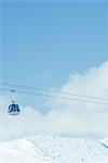 Cable car moving over snow-covered slope