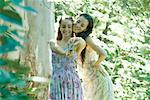 Zwei junge Frauen tragen Sommerbekleidung, im Wald, stehen unter Foto selbst mit Digitalkamera