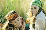 Two young women sitting in field