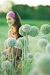 Junge Frau, Schwerpunkt Allium Blumen im Vordergrund