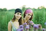 Young women standing in field, thistle in foreground