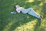 Businesswoman lying in grass, eyes closed