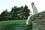 Businesswoman sitting on stone wall