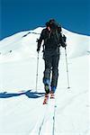 Skier heading toward mountain, rear view