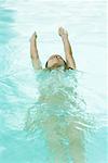 Woman swimming backwards in pool