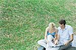 Couple sitting outside, looking at brochure