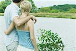 Couple debout en bord de lac ensemble